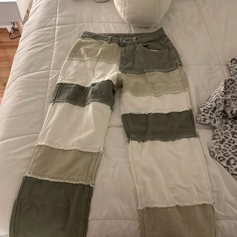 olive green, beige, and white patched jeans